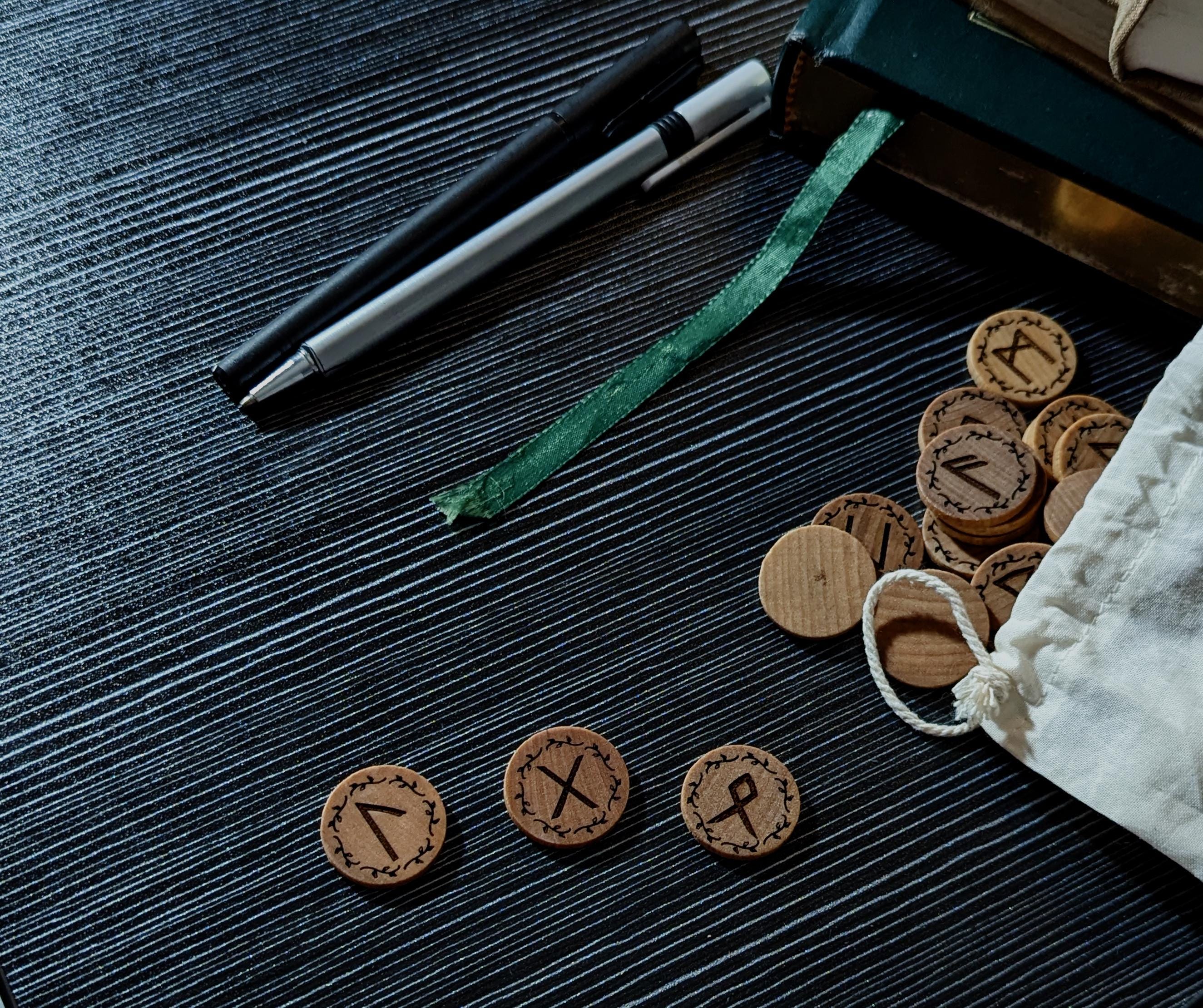 Elder Futhark Rune Set, Handcrafted in Canada. Engraved on real hardwood, displayed on table.