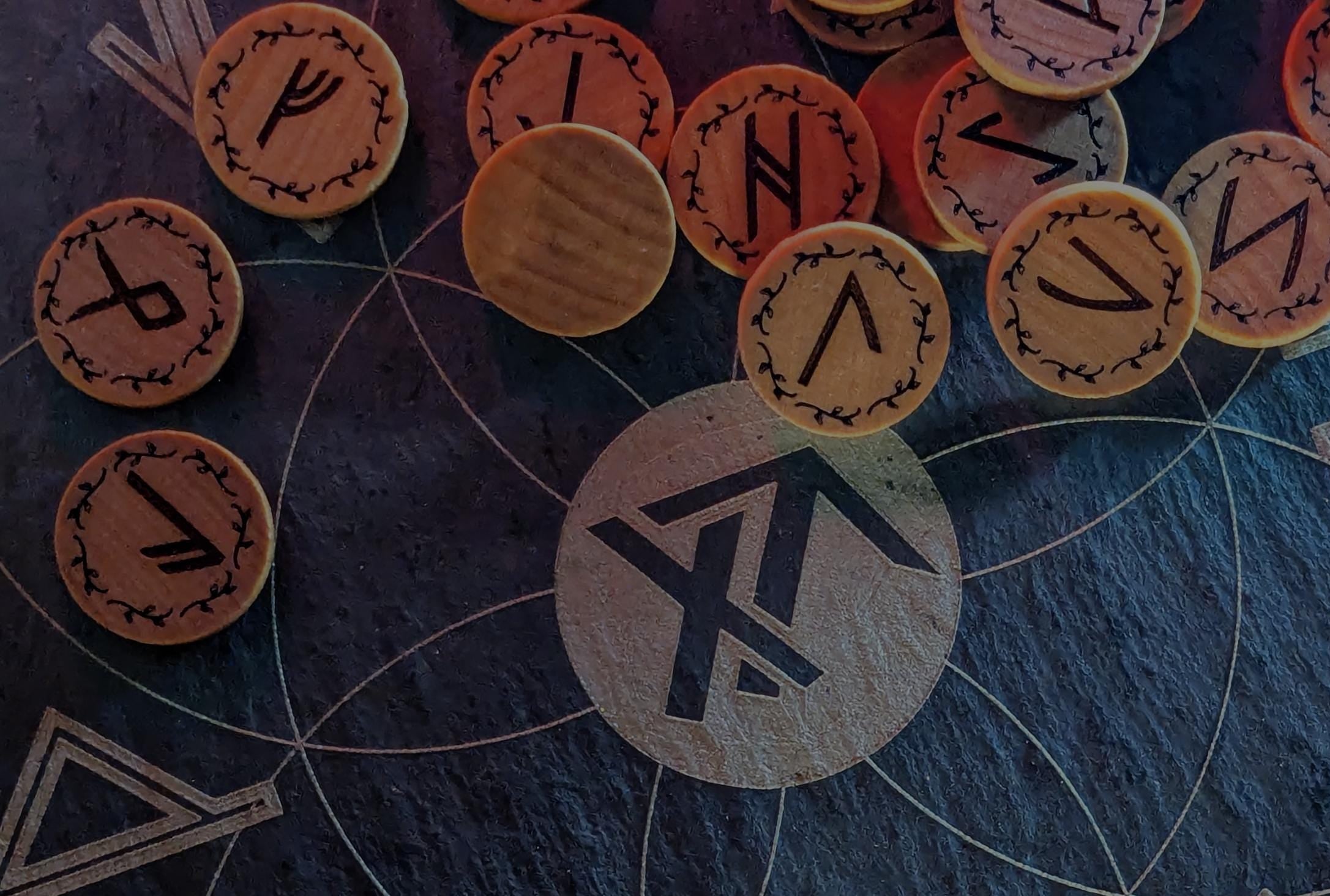 Set of Elder Futhark runes on a dark surface with True North Runes logo