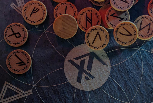 Set of Elder Futhark runes on a dark surface with True North Runes logo