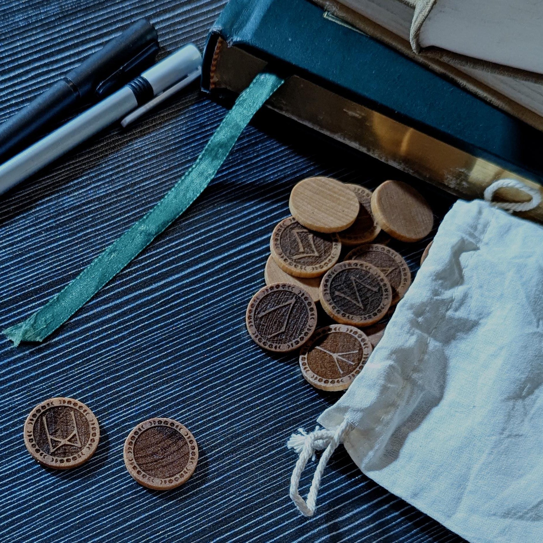 Elder Futhark Rune Set with Lunar Border Displayed on Table. Handcrafted in Canada, engraved on real hardwood.